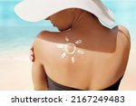 Sun Protection. Beauty Woman Applying Sun Cream Creme on Tanned  Shoulder In Form Of The Sun. . Skin Care. Girl Using Sunscreen to Skin.
