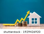 Real estate market, graph, up arrow. House model and a stack of coins. The concept of inflation, economic growth, the price of insurance services