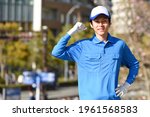 Small photo of A young man in work clothes and a hat doing a guts pose