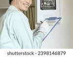 Small photo of Asian male meter reader wearing work clothes indoors