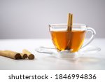 Small photo of A cup of tea, Cinnamon tea, Cinnamon drink with cinnamon stick on a Tea Bag, leaf on a white background, Spoon, Transparent cup, Ceylon Tea, Sri lanka, Ceylon Cinnamon