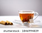 Small photo of A cup of tea, Cinnamon tea, Cinnamon drink with cinnamon stick on a Tea Bag, leaf on a white background, Spoon, Transparent cup, Ceylon Tea, Sri lanka, Ceylon Cinnamon