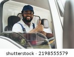 Small photo of Portrait of courier black man in the truck thumb up and smiling to camera while sitting in driver seat, Optimistic man worker with delivery occupation.