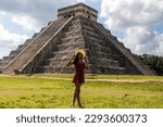 Small photo of Woman with hat in the castle and temple of Chichen Itza known as the famous and apocalyptic Mayan pyramid of Mexico under a blue sky, belonging to the Mayan culture and civilization. Travel concept.