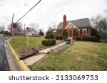 Small photo of Berwyn Heights, Maryland - USA - March 03, 2022: brick house and front lawn in a middle-class suburb area in the Washington Metropolitan region.