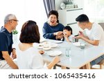 Small photo of Happy Asian extended family having dinner at home full of laughter and happiness
