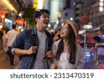 Small photo of Young Asian couple enjoy and have fun outdoor lifestyle together in street market on summer holiday vacation in bangkok, thailand. Happy man and woman feeling surprise about how beautiful the city is
