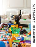 Small photo of Adorable toddlers playing among the many toys at home. A mess in the children's room, a lot of toys in the children's room. Dirty house. Children's room