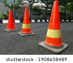Small photo of A row of traffic cones on the road. These objects are temporary traffic control devices for directing and avoiding sections of the road being repaired or diverting traffic.