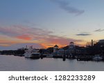 Boats, city skyline and waterfront of Alexandria, Virginia viewed from the water at sunset
