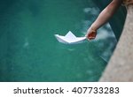 A Kid Putting A Paper Boat Into ...