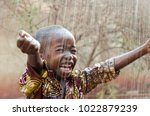 Little Native African Boy Standing Outdoors Under the Rain (Water for Africa Symbol)