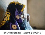 Side view of a veiled black african girl waiting for her wedding ceremony; child marriage concept
