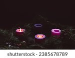 Advent wreath with two candles lit for the second week of advent in a dark room with copy space