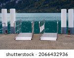 Small photo of Lake Brienz with pier and gangplank on a cloudy autumn day with autumn trees