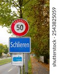 Close-up of traffic sign speed limit 50 and sign of City of Schlieren with text Energy City Gold at Swiss City of Zürich district Altstetten. Photo taken November 11th, 2024, Zurich, Switzerland.