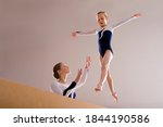 Low angle view of a gymnastics instructor teaching girl on a balance beam.