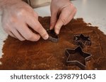 Closeup of man cutting out christmas tree,stars and snowflake shaped cookies