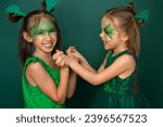Small photo of Laughing funny children with makeup in the guise of a dragon play together. New Year of the Dragon according to the Chinese calendar