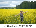 Girl running across a field with yellow flowers