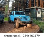 Small photo of Parque Leloir, Argentina - Jul 29, 2023: Modern blue Jeep Wrangler JK Unlimited Rubicon hardtop offroad four door SUV in exhibition on a gravel ground under the trees at a suburban mall.