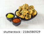 Small photo of Fulwada Bhajiya. Methi bhajiya. Methi gota, Methi pakoda indian gujarati special snack food with chutney dip. Monsoon special gujarati methi bhajiya. Fulvada serving on white texture background.