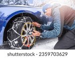 Putting snow chains on the front wheel of the drive axle.