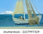 Office work on a sailing boat near a sandy beach by the sea, partly cloudy blue sky. Concept: home office. Miniature Figure Scene