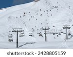 A chairlift and skiers on piste at passo sella in the dolomite mountains, south tyrol, italy, europe