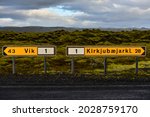 Road signs on Route One (Ring Road) showing the distances to the villages of Vík and Kirkjubæjarklaustur amidst the moss-covered lava fields of southern Iceland