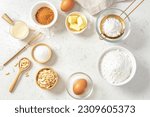 Small photo of Baking and cake ingredients in bowls, butter, milk, nuts and eggs with gold flour sieve and whisk on marble background, flatlay