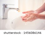 Washing hands with soap under the faucet with water. Hygiene concept.