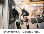 Closeup of woman pumping gasoline fuel in car at gas station. Petrol or gasoline being pumped into a motor. Transport concept