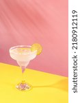 Small photo of Glass of delicious margarita cocktail isolated over pink yellow background. Popular taste. Party time. Concept of cocktails, alcoholic drinks, taste, party, mix. Copy space for ad. Retro style