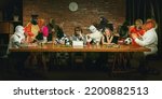 Small photo of Group of people standing, sitting at the long table in different costumes, indoors and lively communicating. Funny, modern replica of last supper painting. Comical life situation