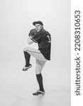 Small photo of Portrait of young man, baseball player, pitcher training, playing. Black and white photography. Innings. Competition. Sport, retro style, 20s, fashion, action, college sport and youth culture concept