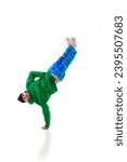 Small photo of Young sportive man, dude wearing stylishly sport cloth dancing hip-hop, breakdance elements, freezes against white background. Concept of action, beauty, sport, youth. Dancer shows breakdance figures
