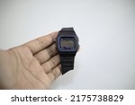 Front view of a black used to watch with a broken strap, on a white background.