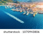 Aerial view of boats, yahts, floating ship and beautiful architecture at sunset in Marmaris, Turkey. Landscape with boats in marina bay, blue sea, city. Top view of harbor with yacht and sailboat.