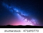 Milky Way and pink light at mountains. Night colorful landscape. Starry sky with hills at summer. Beautiful Universe. Space background with galaxy. Travel background