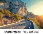 Asphalt road. Colorful landscape with beautiful mountain road with a perfect asphalt. High rocks, blue sky at sunrise in summer. Vintage toning. Travel background. Highway at mountains
