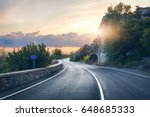 Mountain road. Landscape with rocks, sunny sky with clouds and beautiful asphalt road in the evening in summer. Vintage toning. Travel background. Highway in mountains. Transportation
