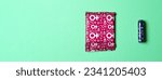 Small photo of A sanitary napkin and a tampon lie on a green background. View from above. Gasket in red packaging. A tampon in a lilac package. Horizontal image. Banner for insertion into site. Flatley