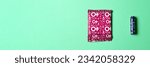 Small photo of A sanitary napkin and a tampon lie on a green background. View from above. Gasket in red packaging. A tampon in a lilac package. Horizontal image. Banner for insertion into site. Flatley
