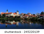 A fairy tale castle and old town with beautiful lakeside reflection on smooth water under clear blue sky in Telc, Czech Republic, Europe ~ A UNESCO world heritage city