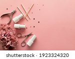 A set of manicure tools and accessories on a pink background with flowers and rhinestones. Nail care. Flat lay. Copy space. Women's Day. March 8