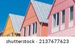Small photo of Panorama lookup view of metal roof on row of new development colorful house with clear blue sky background. Close-up facade of two story townhomes near Wheeler District, Oklahoma City, USA