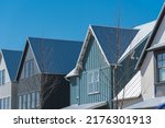 Small photo of Close-up second floor of brand new house with metal roof and covered gutter near Oklahoma City, US. Modern two story townhouse with bay windows and thin brick siding sunny winter day blue sky
