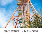Small photo of Double A stand unilateral support, central shaft, slewing bearing, wire rope, outer rim and sightseeing cabin multiple passengers carrying components modern colorful Ferris Wheel, Nha Trang. Vietnam