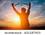 Silhouette image of a businessman with broken chains in sunset.